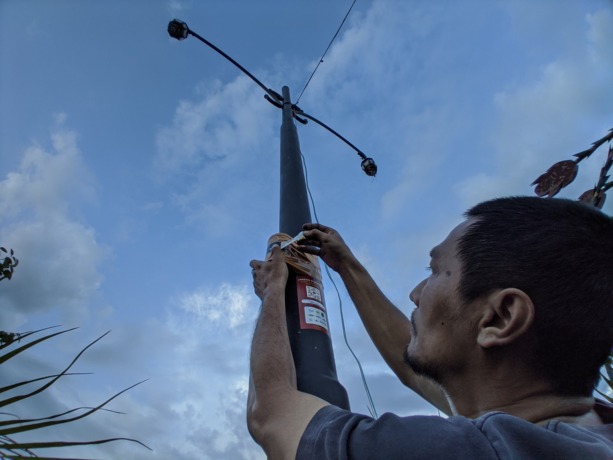 REKAM MATAHARI: Koordinator KFT Tri Yulik Sukmono memasang salah satu KLJ di tiang lampu di pusat kota Trenggalek, Jumat (10/3). (foto: Henny Surya Akbar Purna Putra)